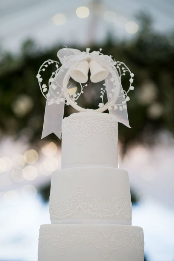 Close up of the top tiers of the 5 tier white lace wedding cake.