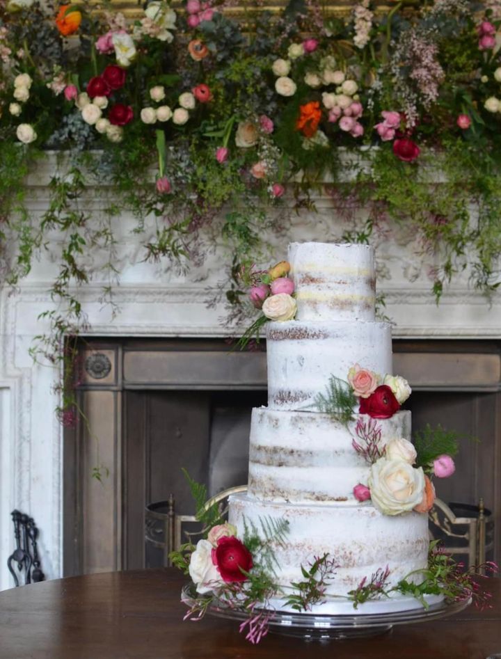 Semi-naked wedding cake at St Giles House. Flowers by SJ floral design