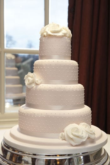 Pink dotty with white roses wedding cake